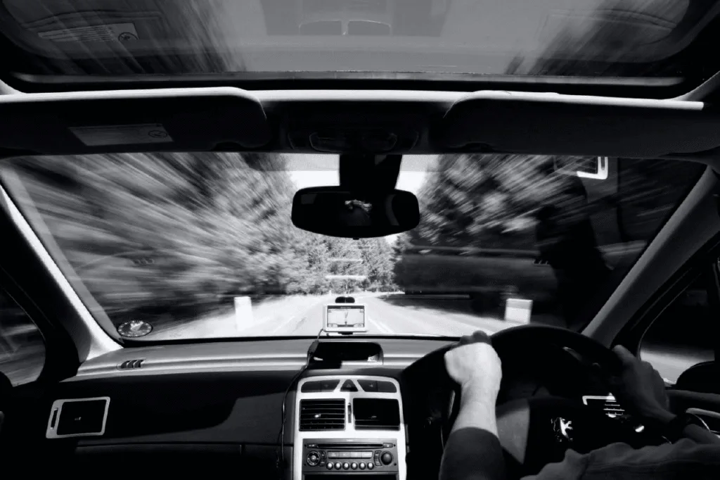 Driver's perspective looking out of the windshield onto a road