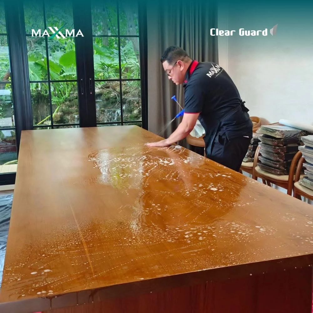 Specialist applying formulated installation fluid onto a solid natural wood slab
